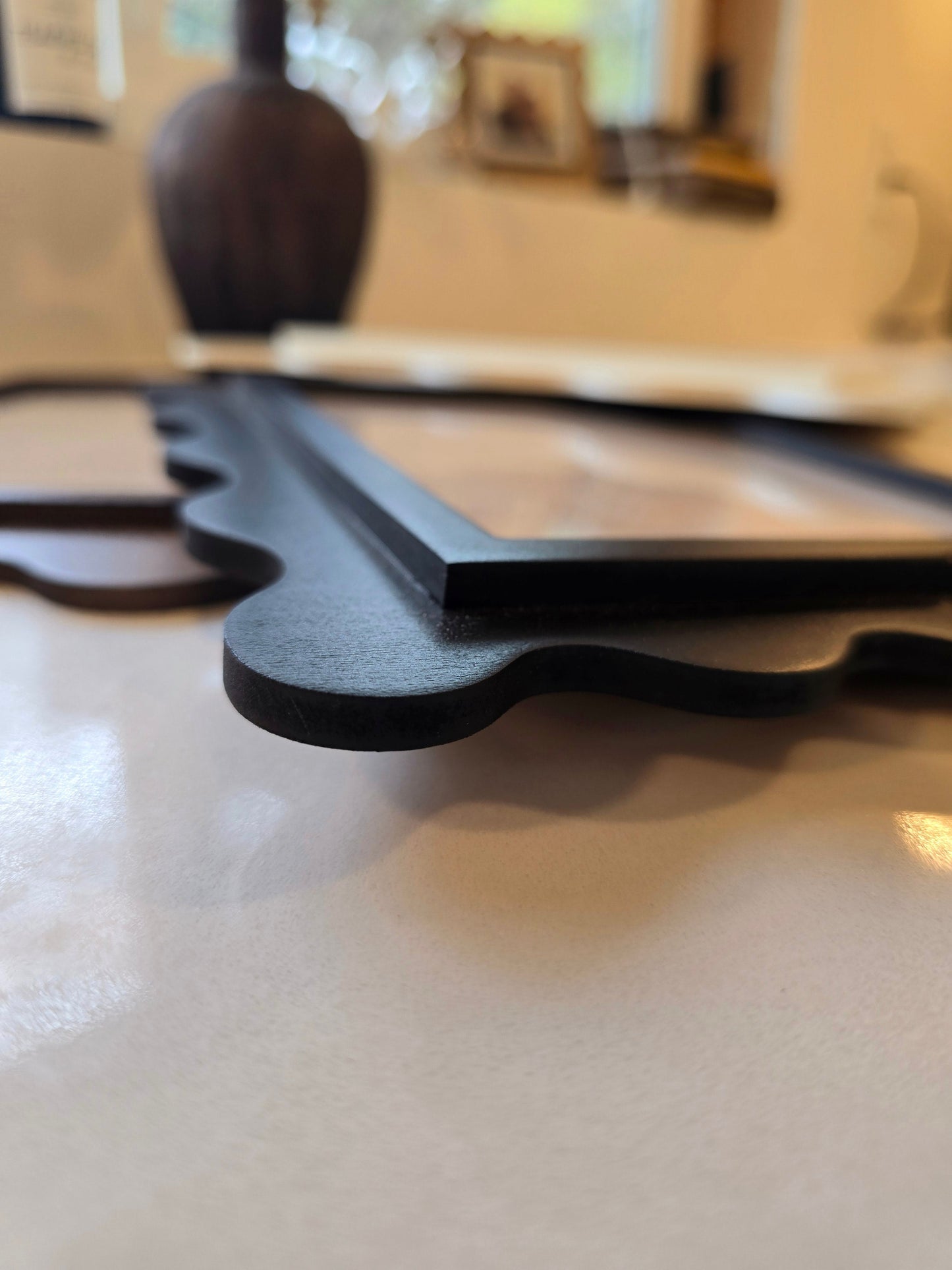 Close-up of scalloped edge on handcrafted maple wood frame with smooth CNC-cut curves