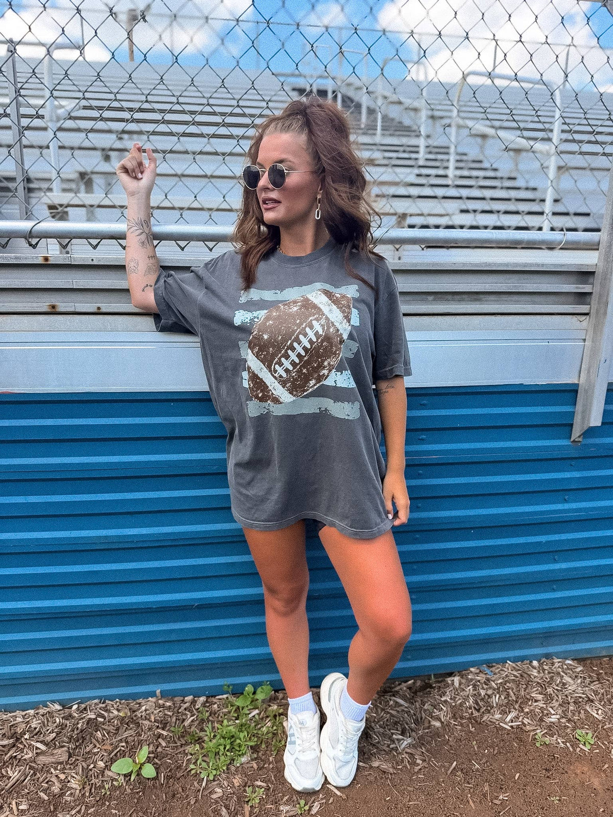 Model wearing pepper-colored retro football graphic tee.