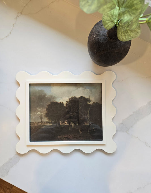 Scalloped edge maple wood picture frame on a neutral wall with art print displayed inside
