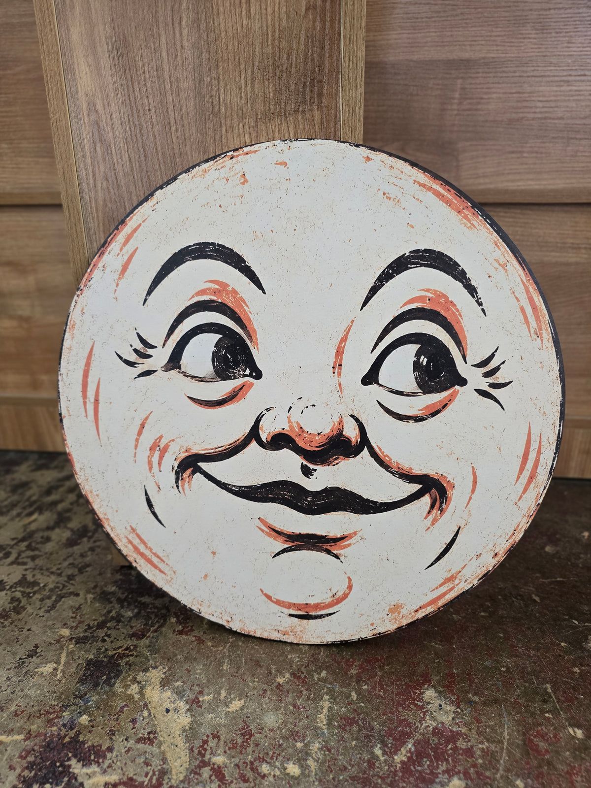 Vintage Man in the Moon Halloween round sign with smiling moon face and distressed black, cream and orange details.