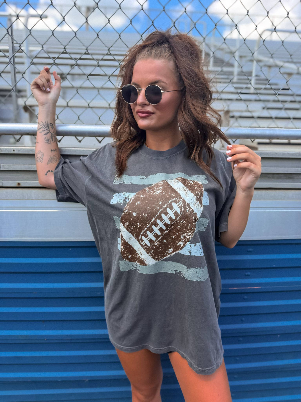 Model wearing pepper-colored retro football graphic tee.