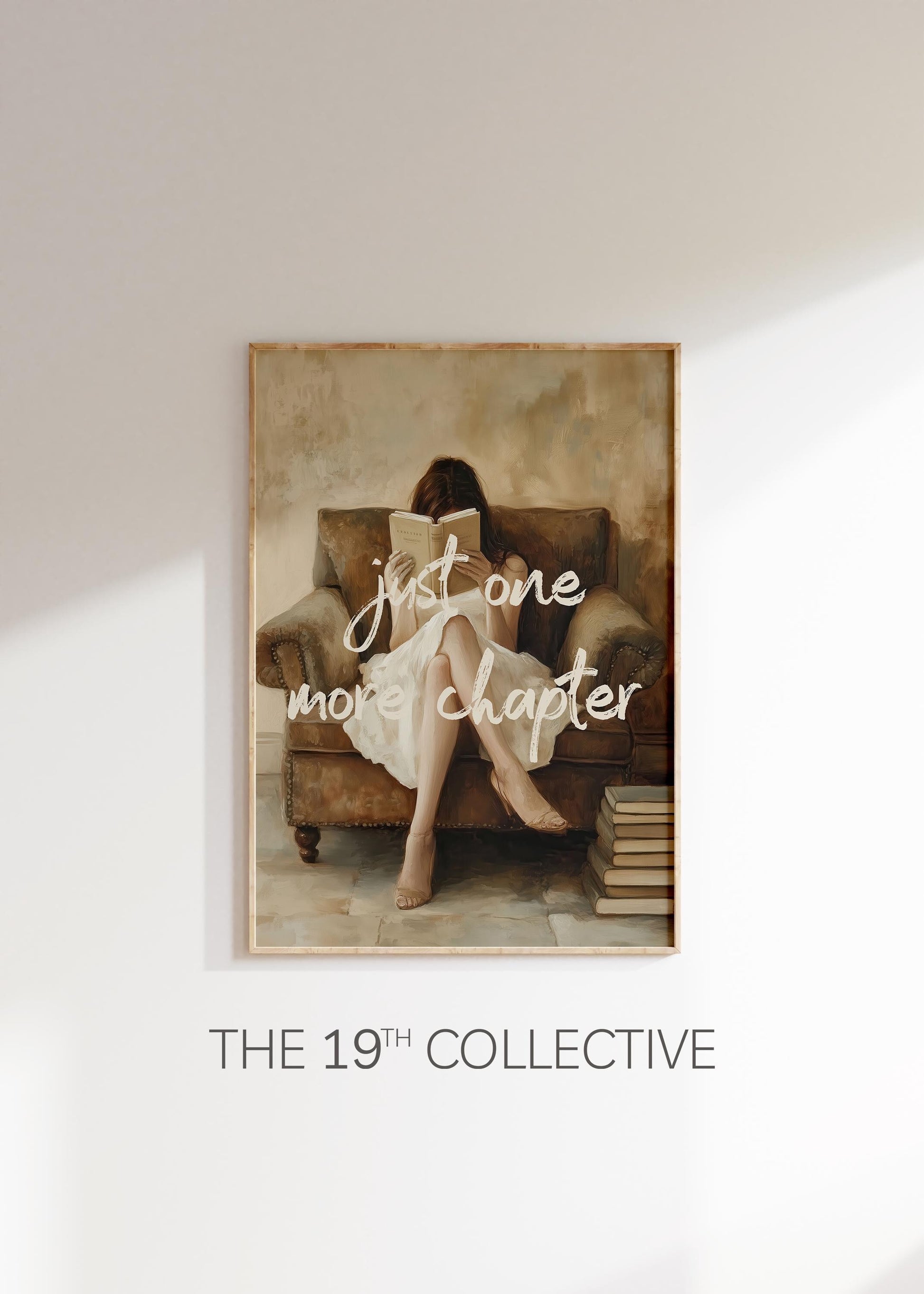 Framed art print of a woman sitting in a cozy armchair reading a book, with the phrase “just one more chapter” in soft white script across the image; warm, neutral tones and vintage-style painting effect